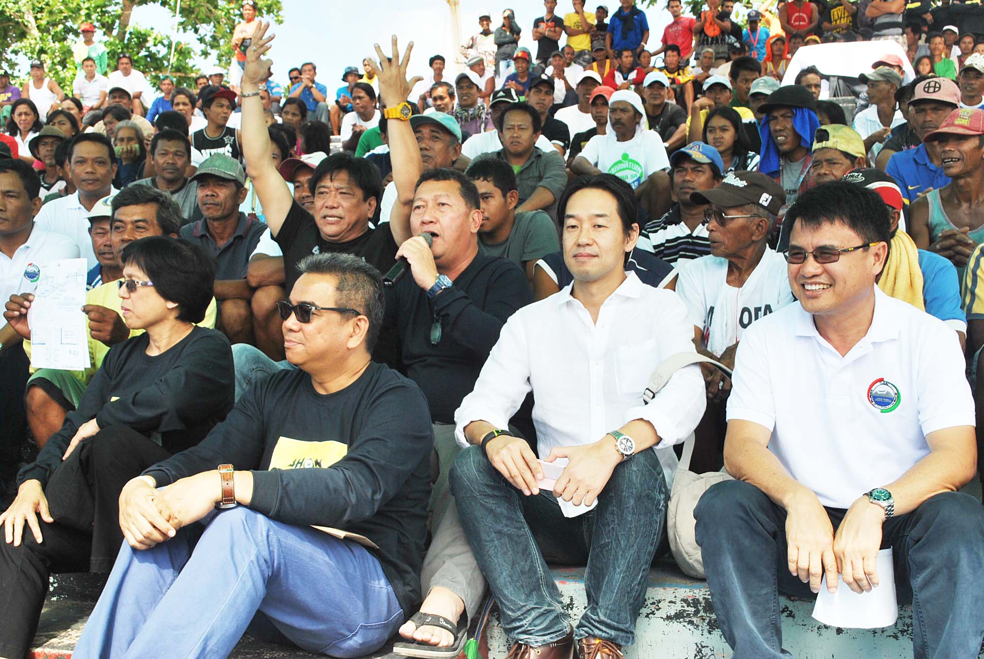 ASSISTANCE. Agriculture Secretary Proceso Alcala (hands raising) lead in the distribution of fishing boats to fishermen who lost their bancas during the supertyphoon Yolanda. Joining him was National Director Asis Perez (holding a microphone) of the Bureau of Fisheries and Aquatic Resources during the simple turn over rites held at the Balyuan Amphitheater in Tacloban last February 25,2014.(TOTEX ARCUENO)