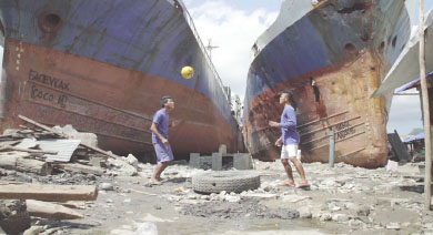Players in front of a vessel washed inland during Yolanda in Anibong area during the filming of “Football Wonders of Tacloban” by UNDP and Embassy of Switzerland.  (Photo Daniel Kunz)