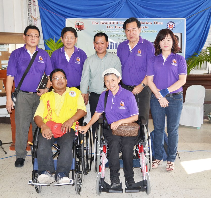 Romulo Advincula, 54, former barangay chairman of Bongdo,  Julita, Leyte, receives his wheelchair from Pastor Sia Siew Chin, executive director of the Beautiful Gate Foundation for the Disabled (BGFD), (right also disabled in wheelchair),  as Leyte Governor Leopoldo Dominico Petilla (center background) witnesses the event.  Also in pictures who witnessed the event were  members of BGFD (l-r): Chew Toh Hie, Gan Ka Bon, Samuel Siah   and Esther Ng.   (Photo by: RESTITUTO A. CAYUBIT)