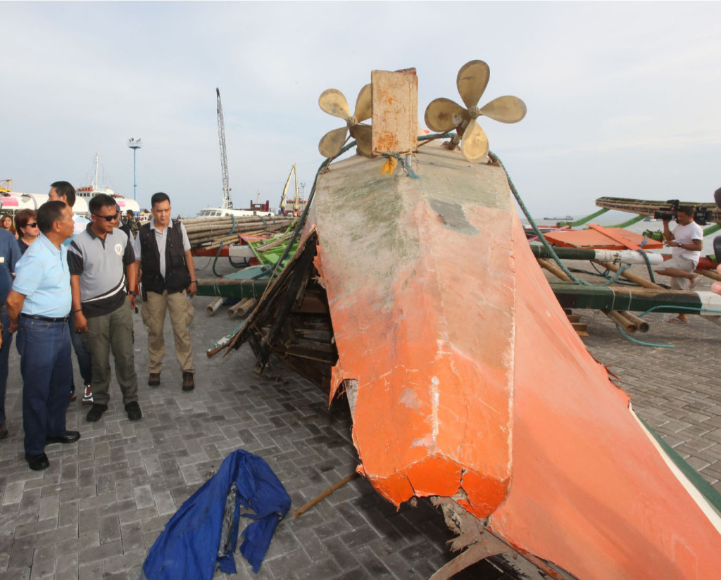 Vice President Jejomar Binay (extreme left) inspects the wreckage of the M/B Kim Nirvana​- B that capsized near Ormoc City Port​, killing 62 passengers. The wreckage shown is the upside down rear or the stern portion of the boat showing the rudder and the two propellers.   (Restituto A. Cayubit/OVP photo) 